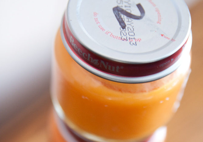 orange baby food puree in a glass jar