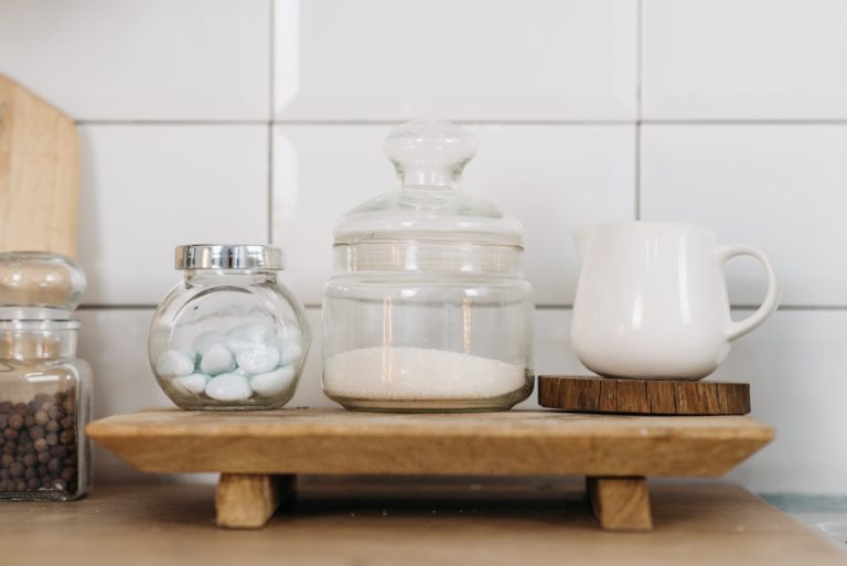 glass jars and ceramic cup on wooden coaster
