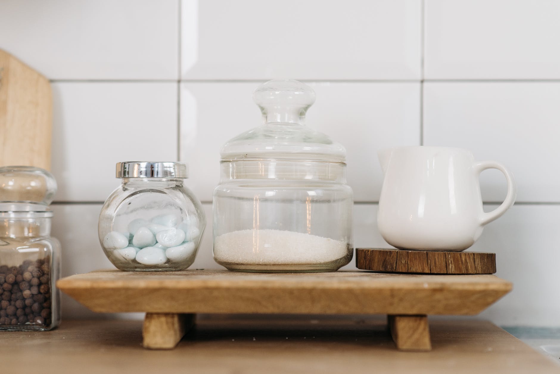 glass jars and ceramic cup on wooden coaster